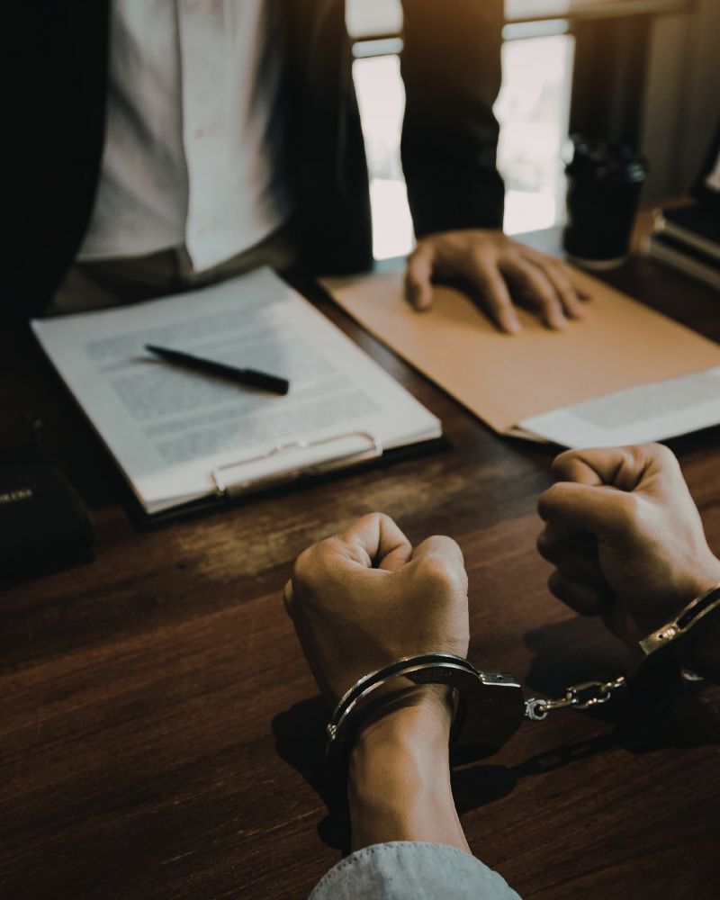 Handcuffed individual consulting with a lawyer representing assault and criminal defense in Washington, DC